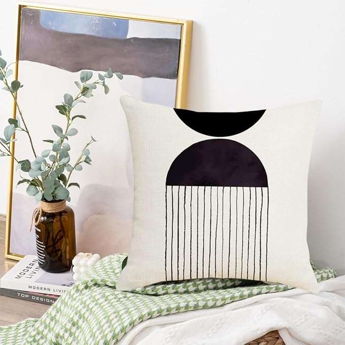 Mid century modern black and white tufted pillow cover with handwoven geometric design, adding texture and comfort to a cozy living room or bedroom setting.
