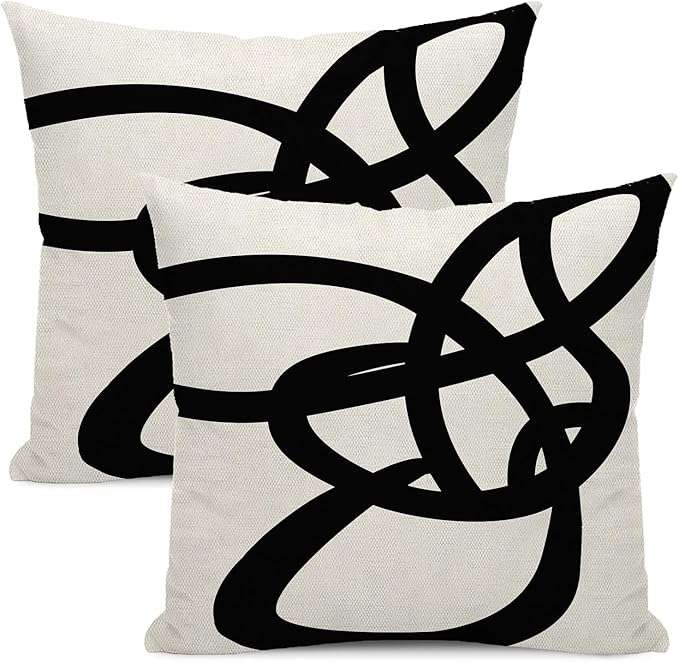 Farmhouse-style black and white striped patchwork throw pillow cover displayed on a couch, ideal for modern rustic living room decor and mixing with other accent pillows.